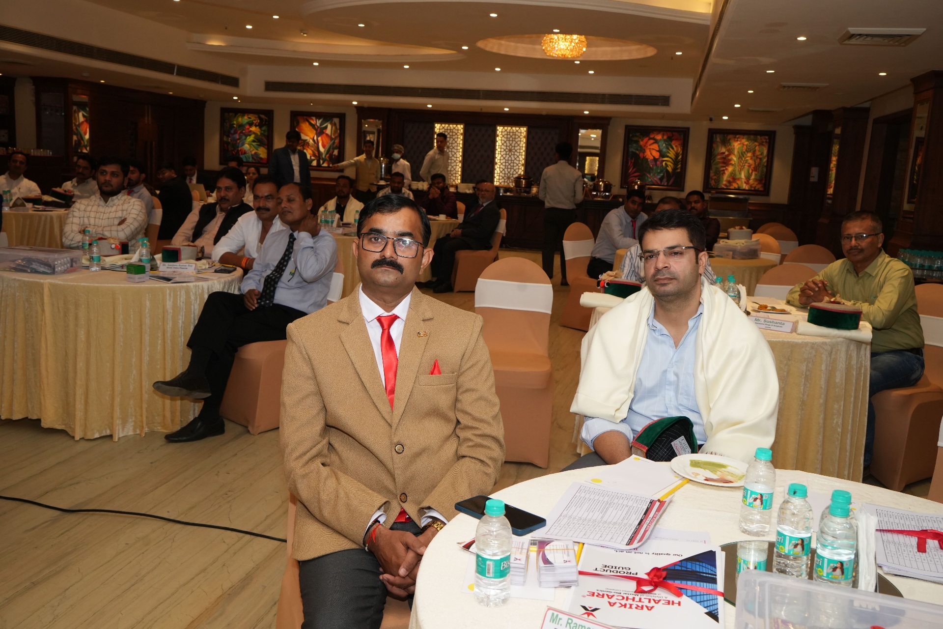 Distributors felicitated with shawls and Himachali caps seated at the event
