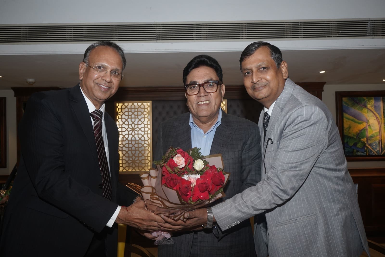 Arika leaders presenting a bouquet of roses to a senior guest at the event