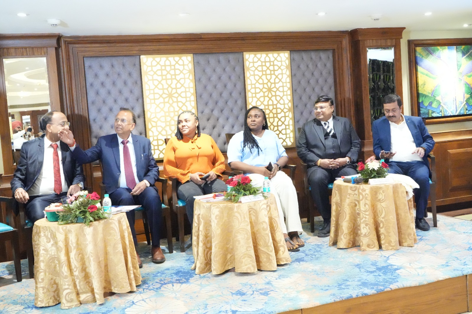 Panel of Indian and African guests seated at an event