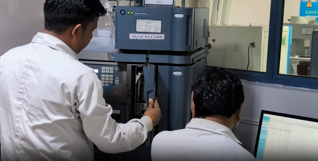 QC analysts operating Waters UV/Vis HPLC detector